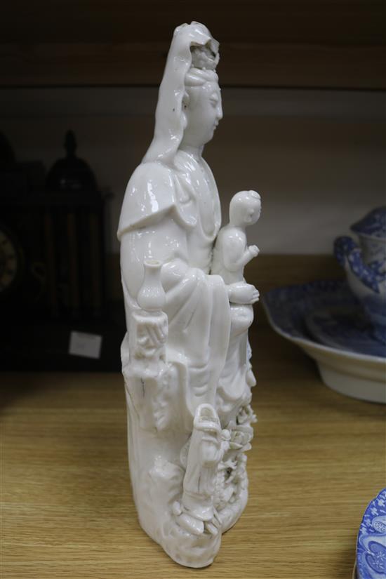 A large Chinese blanc de chine group of Guanyin and child, Kangxi period, damage and losses